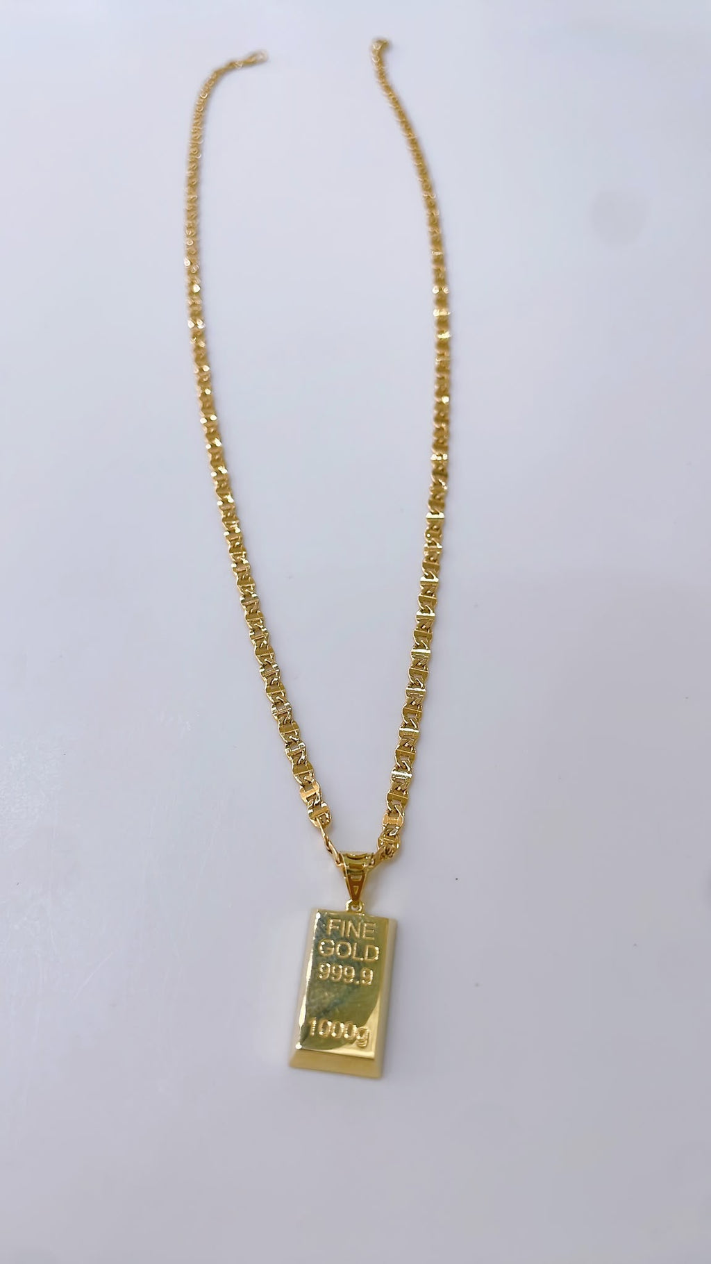 Byzantine-style necklace with a gold bar replica pendant.

Crafted entirely in 18kt gold.

Length: 50 cm
Total weight: 7.3 g