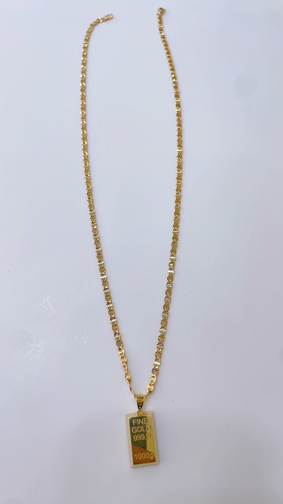 Byzantine-style necklace with a gold bar replica pendant.

Crafted entirely in 18kt gold.

Length: 50 cm
Total weight: 7.3 g