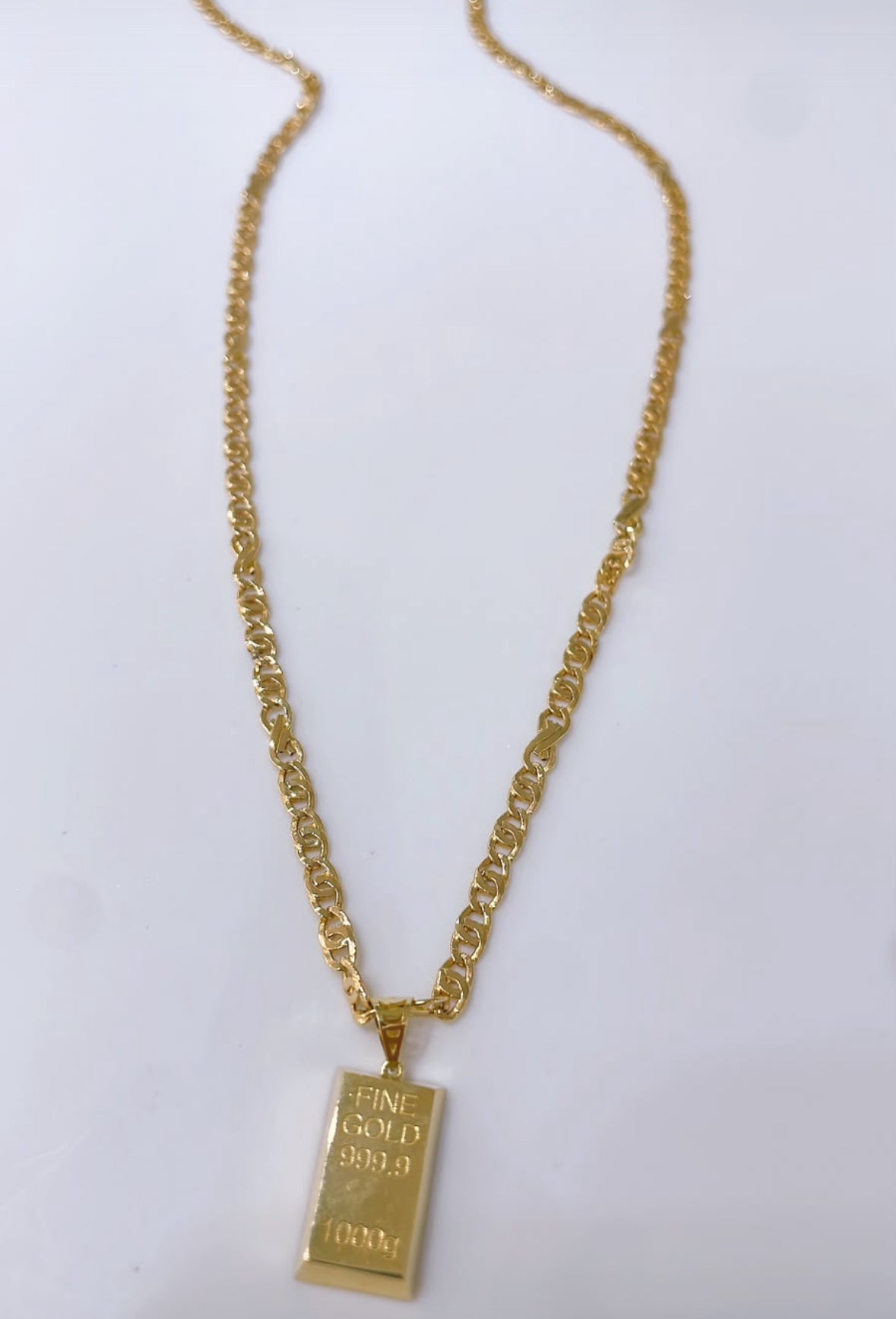 Byzantine-style necklace with a gold bar replica pendant.

Crafted entirely in 18kt gold.

Length: 50 cm
Total weight: 7.3 g