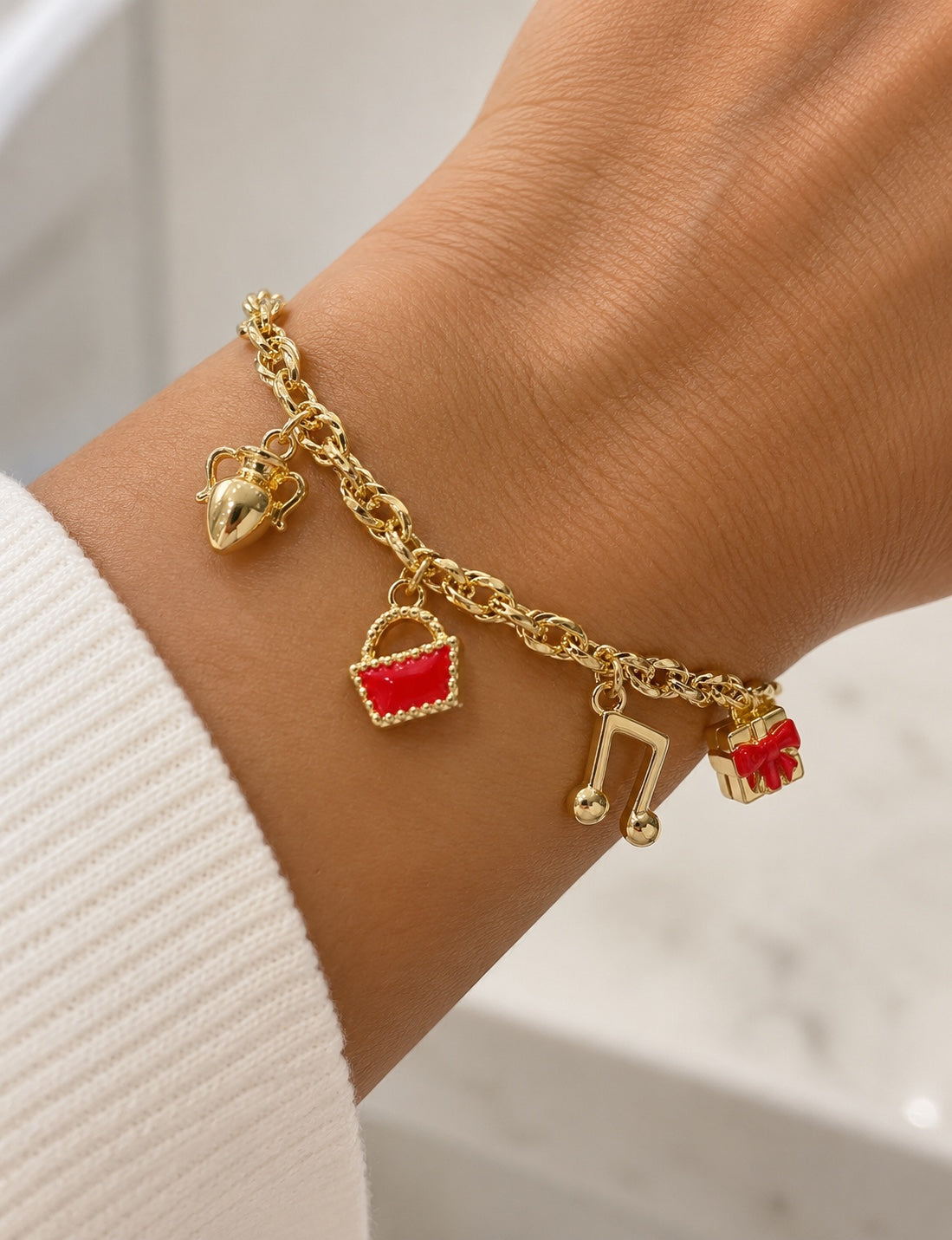 Bracciale a catena con charme in oro 18 kt indossato al polso